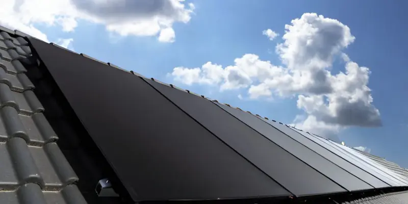 Een dak vol zonnepanelen van Solar Power Systems onder een blauwe lucht.